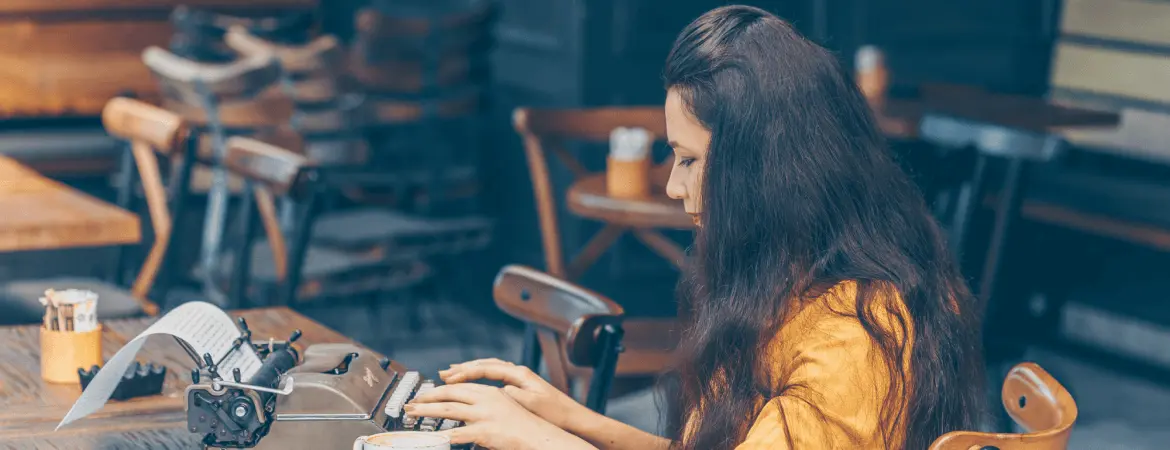 Female author typing on typewriter