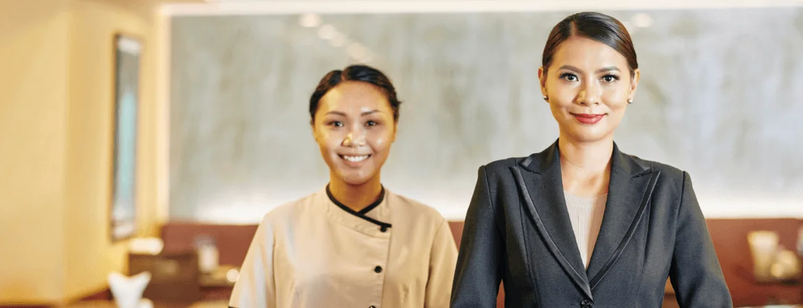 hotel staff welcoming guests at reception desk in a luxury hospitality environment.