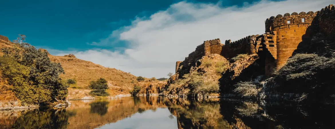 Historic Madan Mahal Fort near a tranquil lake surrounded by hills in Jabalpur, Madhya Pradesh.